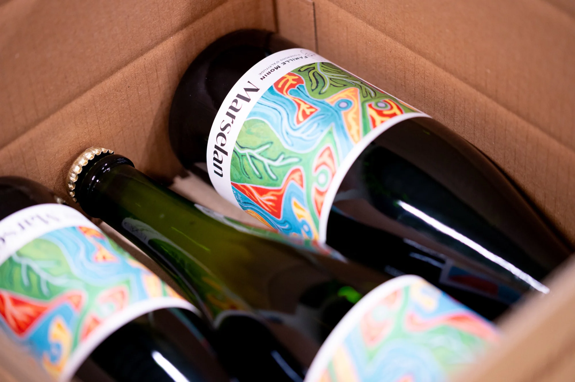 Bouteilles de vin étiquetées rangées dans un carton