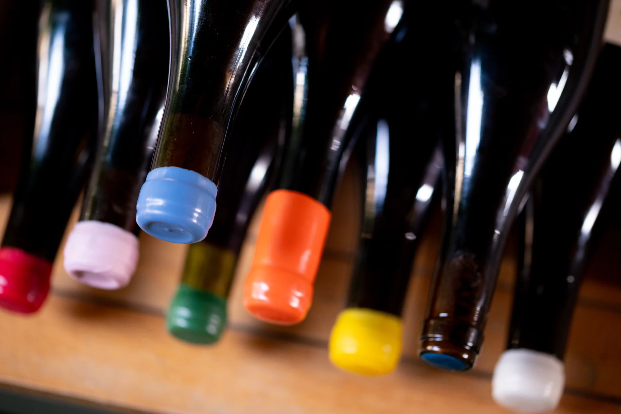 Bouteilles de vin aux capsules de cire bleue, rose, orange, verte et jaune